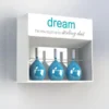 Wall-mounted acrylic cosmetic display cabinet with three blue perfume bottles and a white branded header reading "dream – the new fragrance by Stirling Dust".