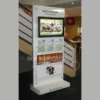 Freestanding multimedia display with 32-inch LCD screen, A4 leaflet holders, and poster space in a retail or public setting.