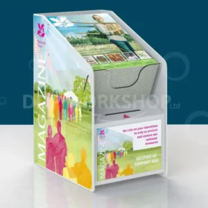 Colourful countertop display combining a donation collection box and magazine holder, featuring custom graphics and a front donation slot.