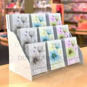 Three-tier white Perspex greeting card display stand holding A5 floral cards, placed on a retail countertop.