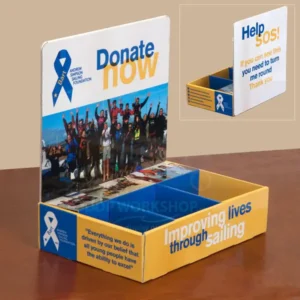 Laminated cardboard table top point-of-sale display unit with full-colour “Donate Now” branding and three channels for literature or donation materials.