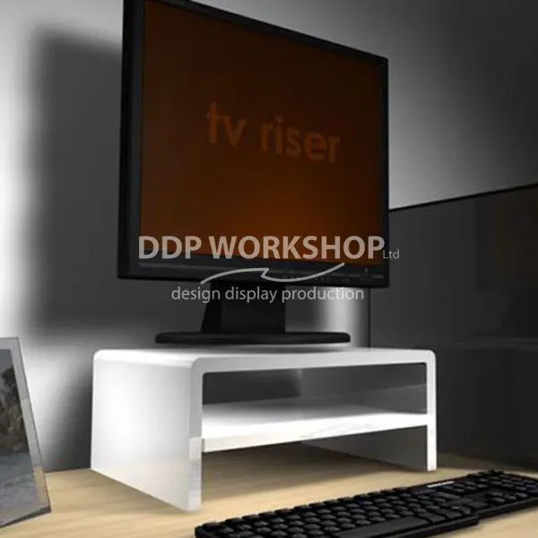 White acrylic TV riser with an integrated shelf holding a monitor on a wooden desk, accompanied by a keyboard.