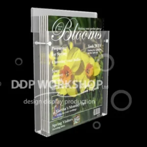 Clear acrylic hook-over media display holding A4-sized "Blooms" magazines, mounted on a black background.