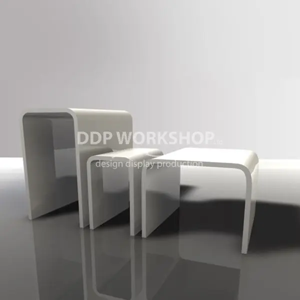 Set of three white acrylic bridge risers with polished edges, arranged by size on a glossy surface.
