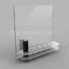 Clear acrylic lipstick display stand with ten circular slots and a vertical back panel for graphic insertion, holding two black lipsticks.