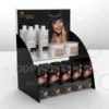 Two-tier black acrylic beauty product display with clear shelves and a customisable header graphic panel