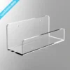 Clear wall-mounted acrylic shelf with polished edges and front lip, designed for displaying books or brochures.