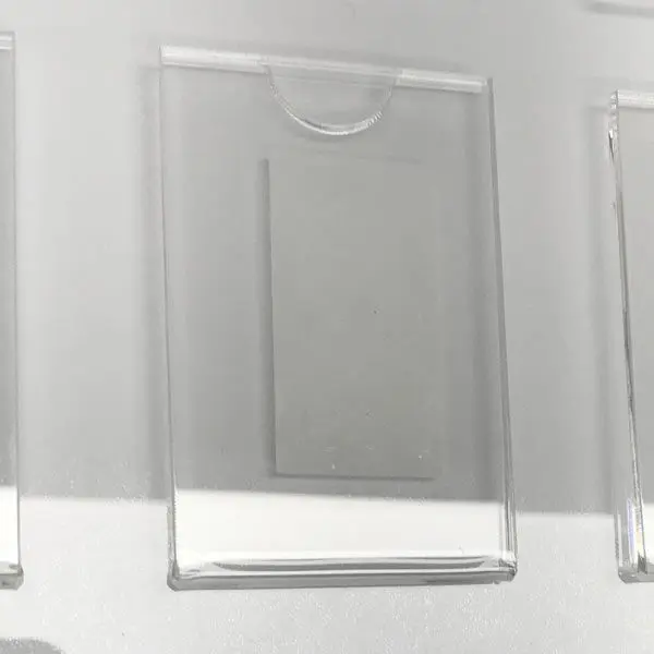 Clear acrylic photo pocket with a semicircle thumb cutout, designed to hold 50x74mm portrait images.