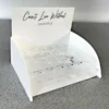 White and clear acrylic curved countertop lipstick display stand with a branded header and multiple tester slots.