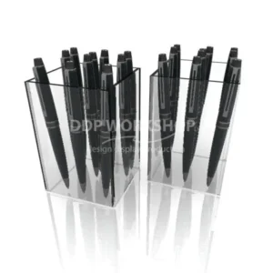 Clear acrylic tub display holding multiple black pens in a vertical arrangement.