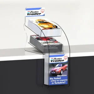 Clear acrylic teardrop-shaped 3-tier magazine display holding Auto Trader magazines on a counter.