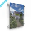 Wall-mounted floating acrylic frame displaying a "House for Sale" poster, fixed with satin silver standoffs.