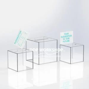 Three transparent acrylic ballot boxes of varying sizes with top posting slots, shown with suggestion cards.