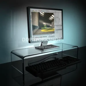 Clear acrylic monitor riser elevating a computer screen, with keyboard stored neatly underneath.