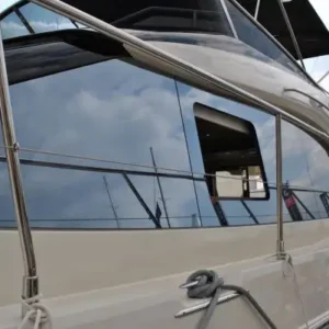 Close-up of a luxury boat featuring sleek, reflective acrylic replacement windows fitted into the hull, showcasing clean marine-grade installation.