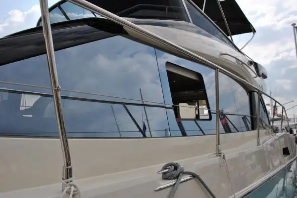Close-up of a luxury boat featuring sleek, reflective acrylic replacement windows fitted into the hull, showcasing clean marine-grade installation.