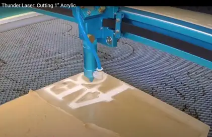 High-precision laser cutting machine in action, slicing through thick acrylic sheeting with clean detail.