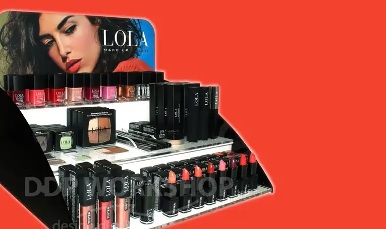 Lola branded cosmetic display stand showcasing a full range of makeup products including lipsticks, nail polishes, and compacts, designed by DDP Workshop.